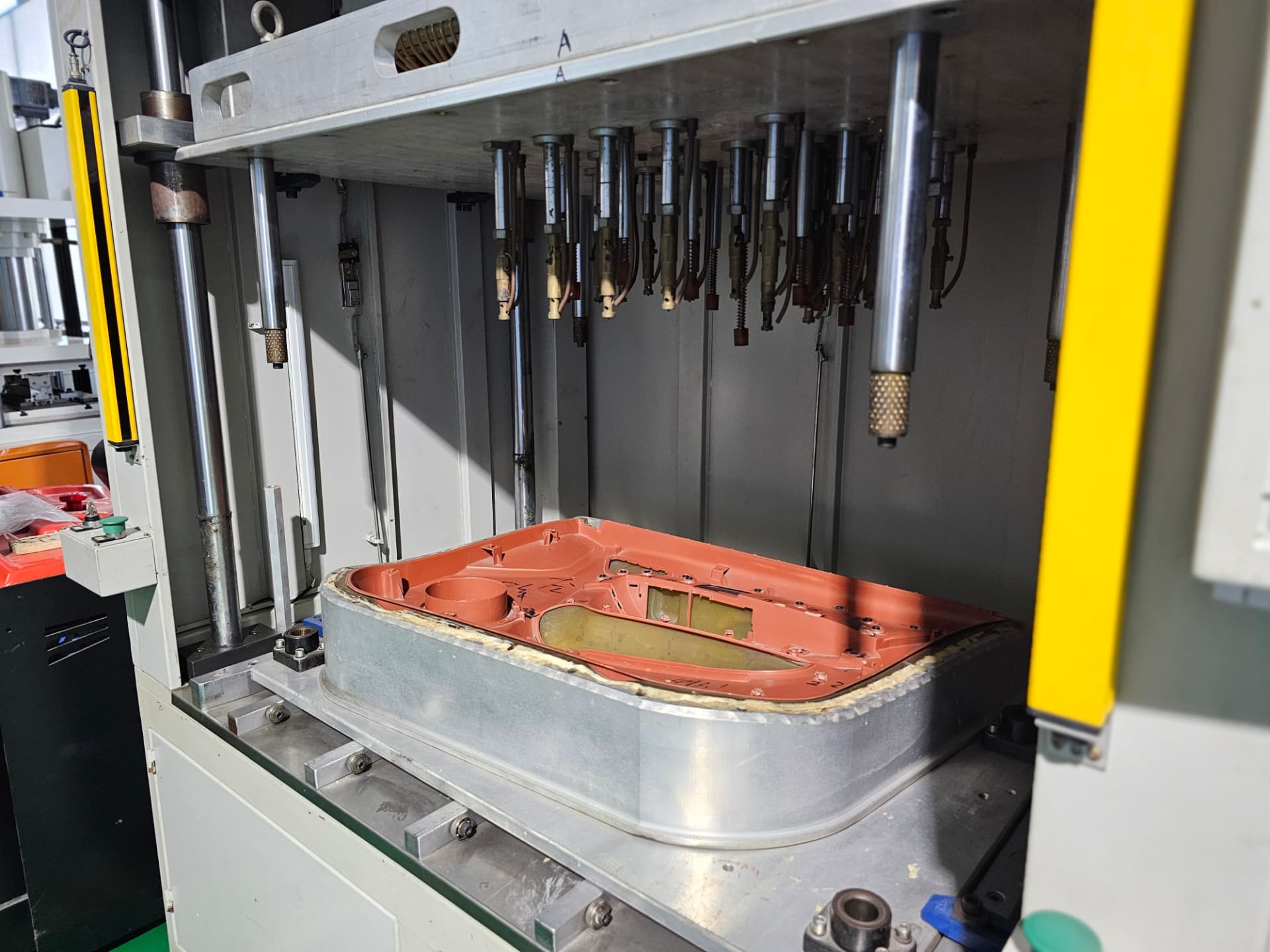 Heat-stake press with door trim substrate under the tooling head