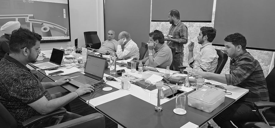 Team CAD review with physical reference parts on the table